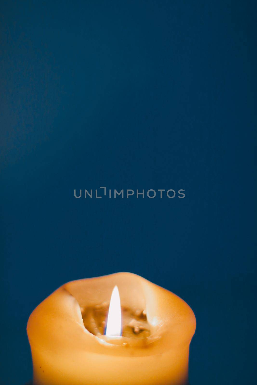 Happy holidays, greeting card backdrop and winter season concept - Yellow holiday candle on blue background, luxury branding design and decoration for Christmas, New Years Eve and Valentines Day