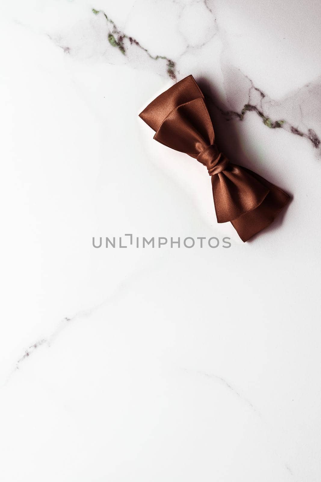 Holiday gift, decoration and sale promotion concept - Chocolate brown silk ribbon on marble background, flatlay