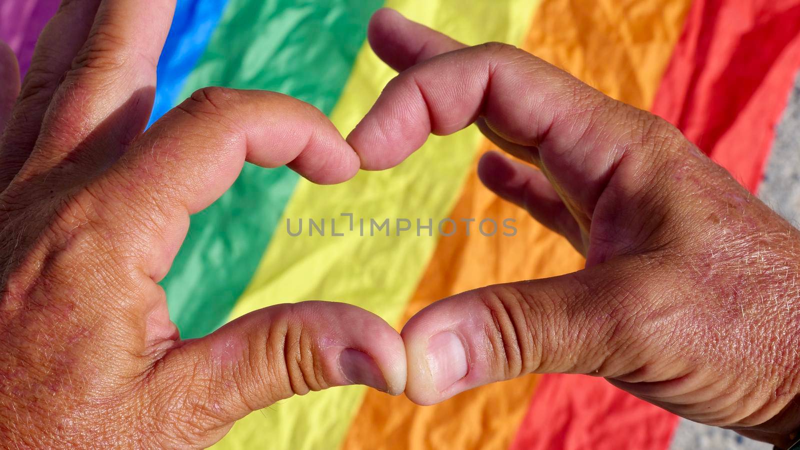 Bisexual, gay, man, person, homosexual holds heart on LGBT flag background and celebrating a gay parade, Bisexuality Day or National Coming Out Day in pride month