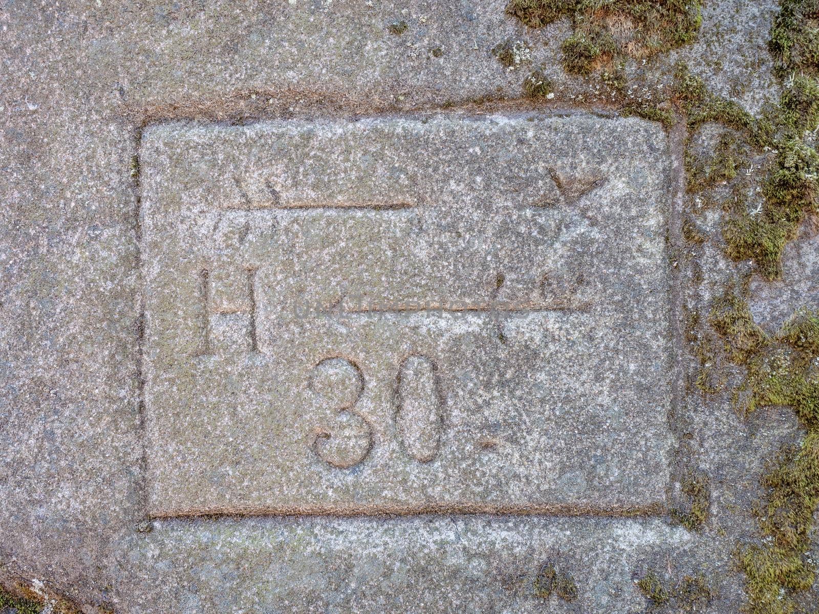 Old tourist arrows and direction symbols with letters engraved into soft sandstone. Some characters engraved in a rock. Thirty minutes walk