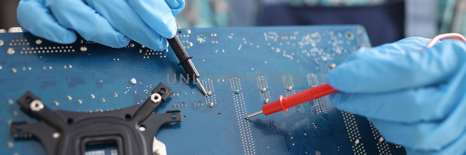 Repairman diagnosing breakdown in computer motherboard using tester closeup by kuprevich