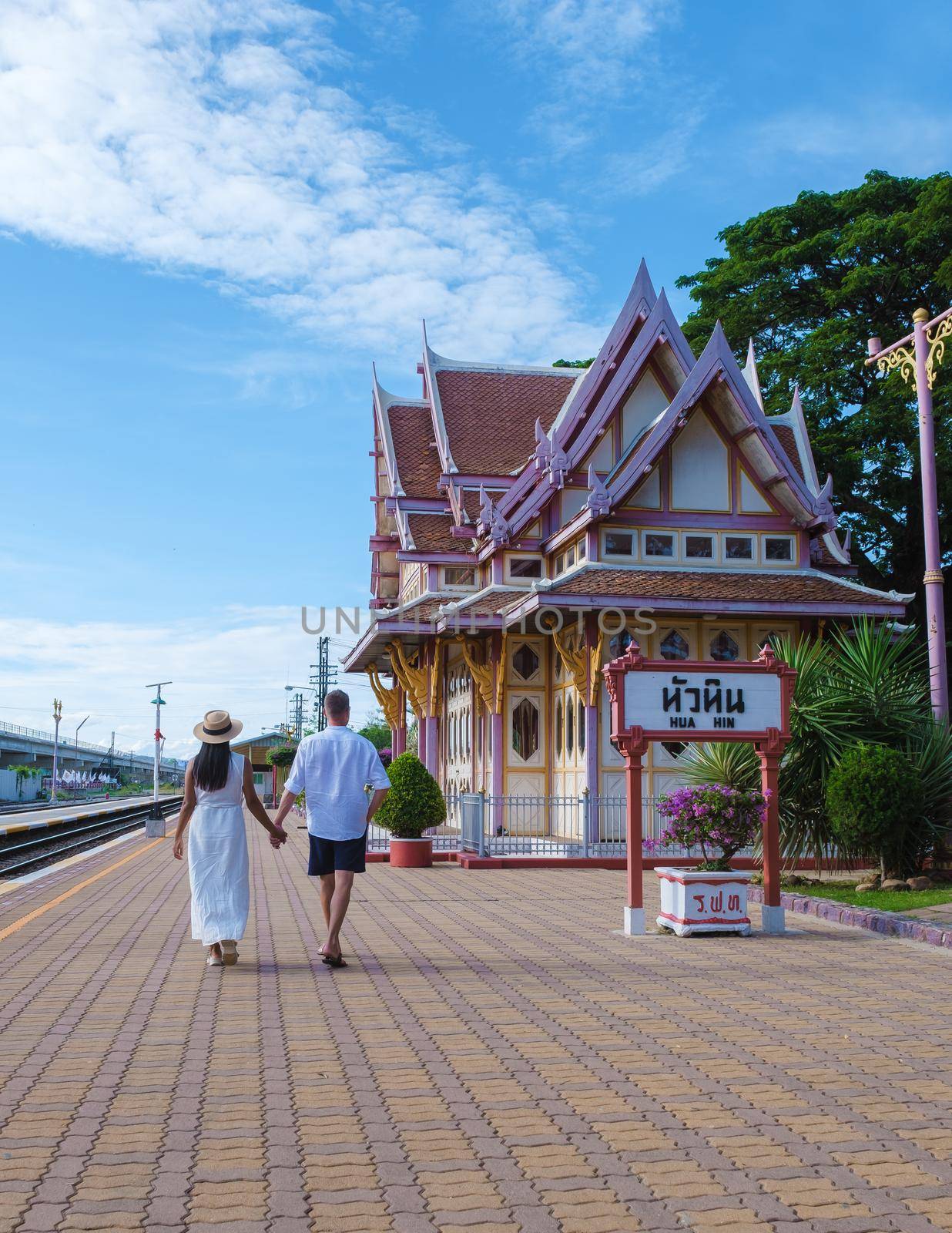 Hua Hin train station in Thailand on a bright day, men and women walking at train station Huahin by fokkebok