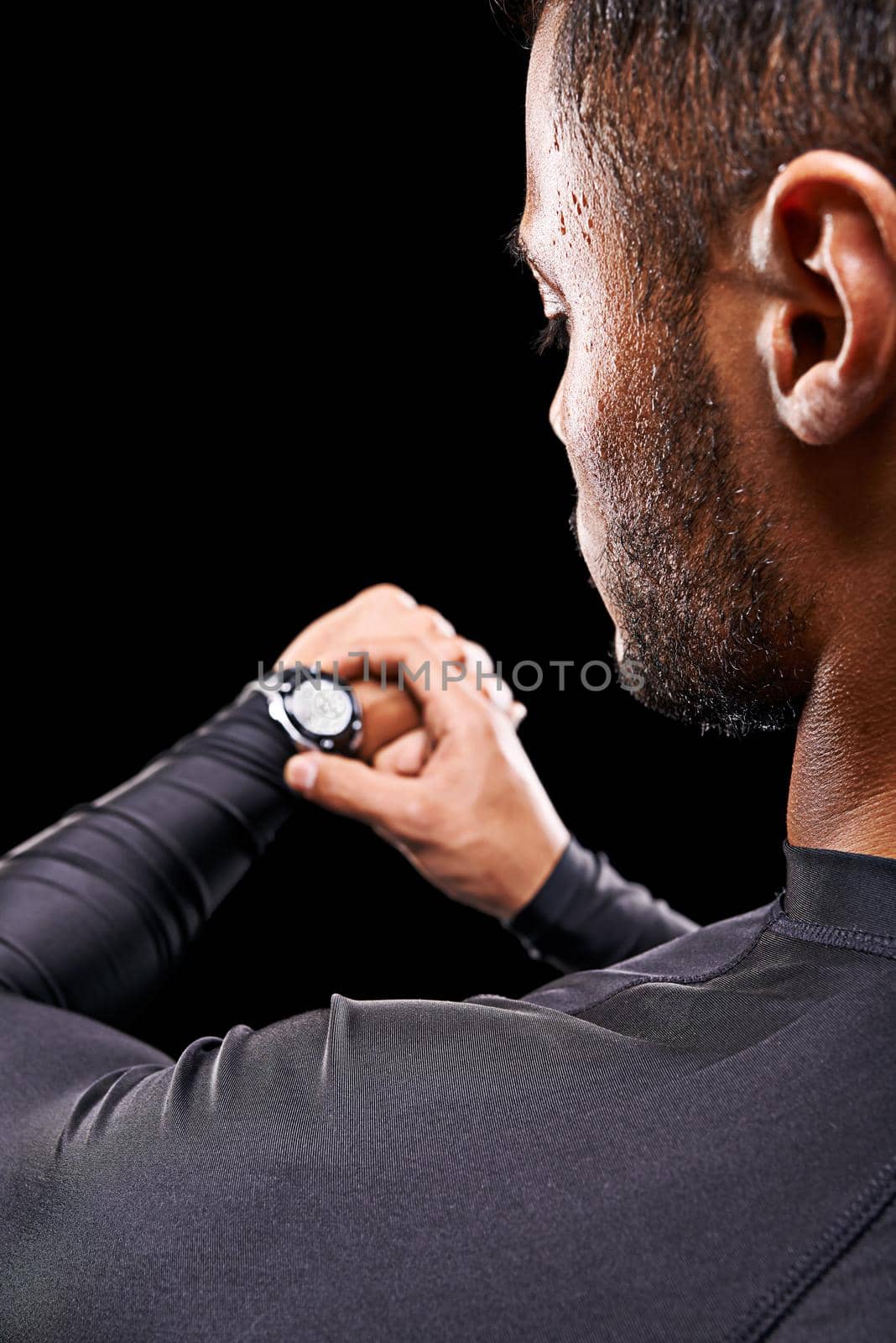 Right on time. Rear view shot of a young athlete checking his sportswatch