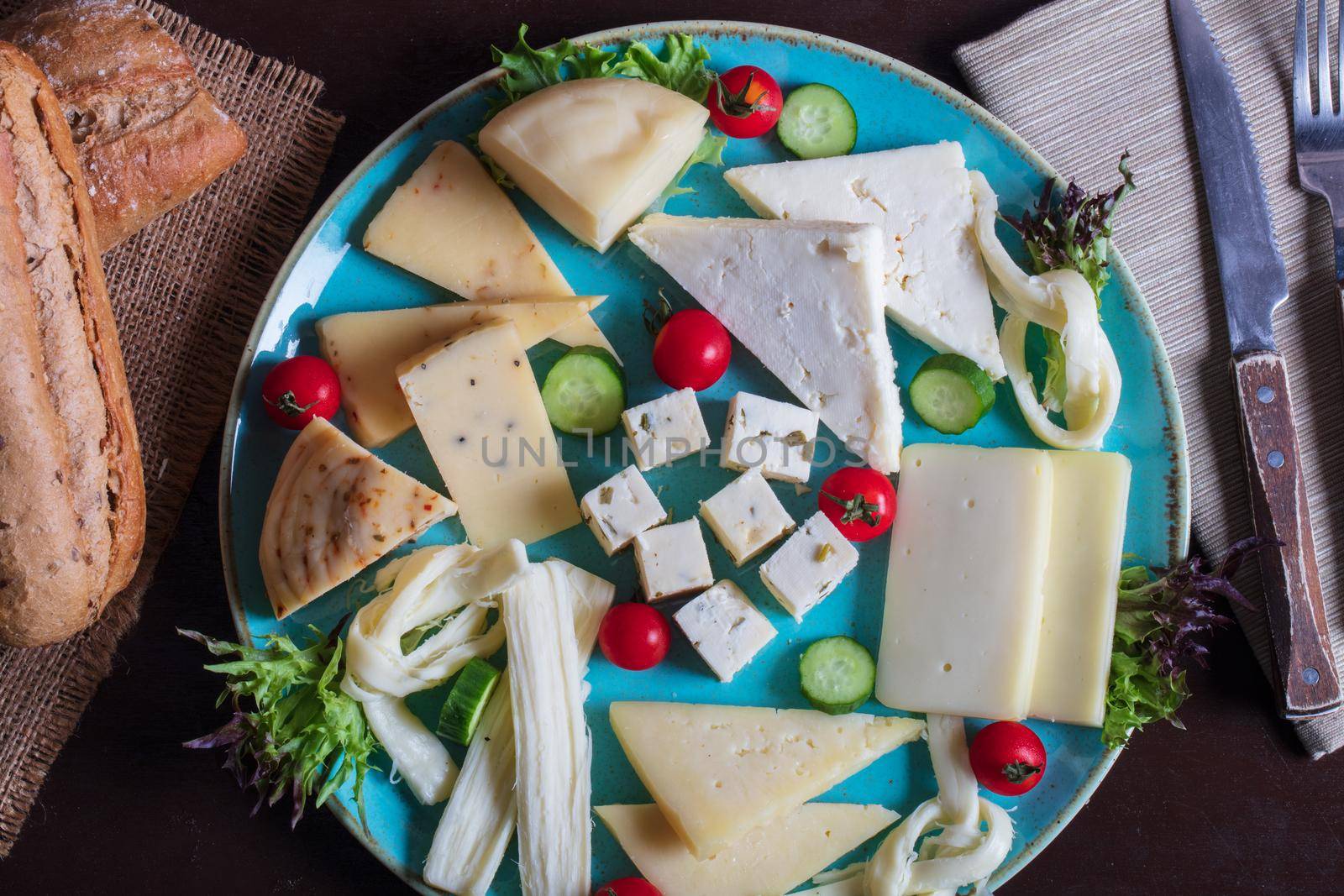Cheese plate on a dark table. Many kinds of cheese on a plate. High quality photo