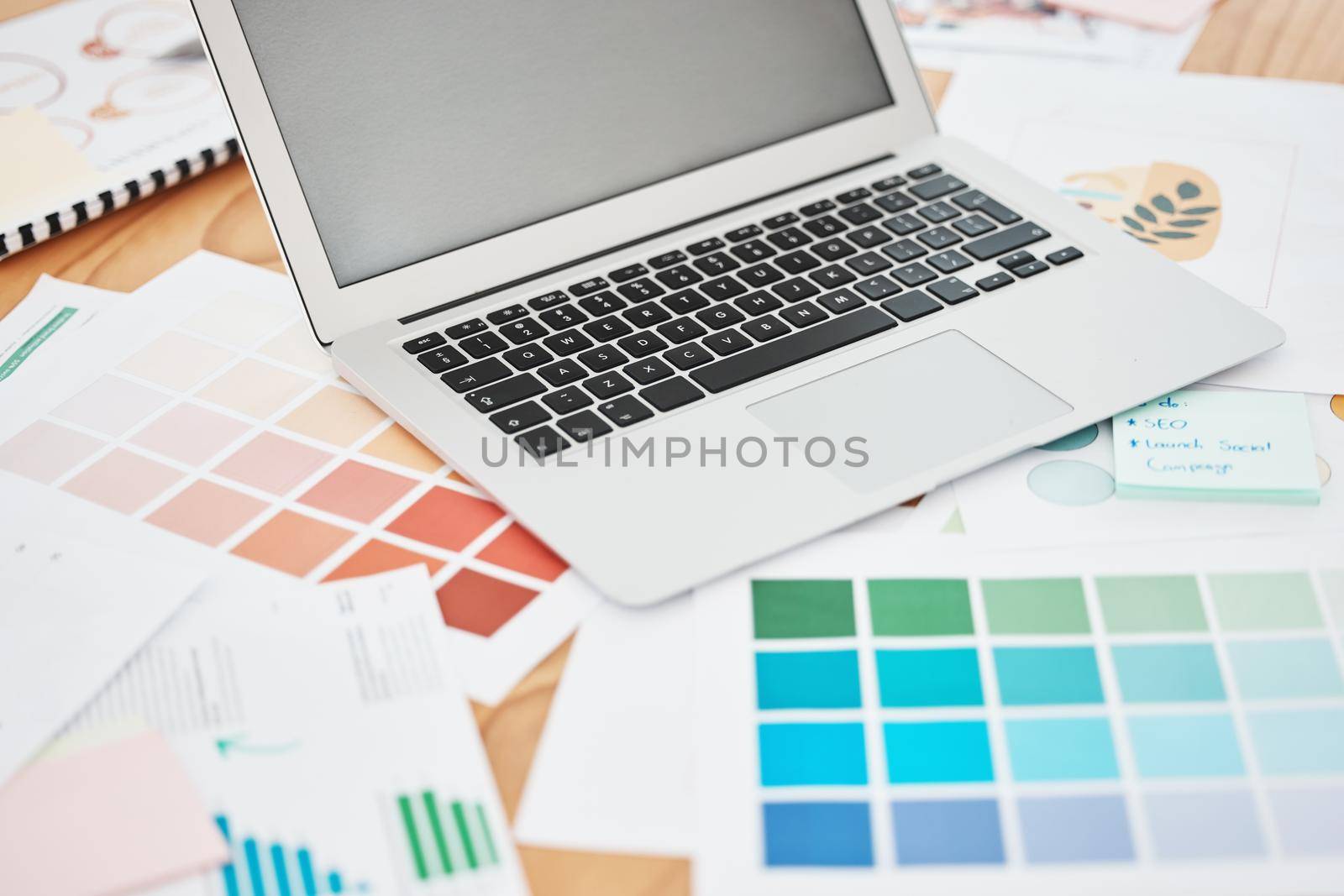 Creative color swatch, laptop planning and paperwork for designer, marketing and advertising strategy on office desk. Background creativity project, art documents and paint catalog for online graphic.