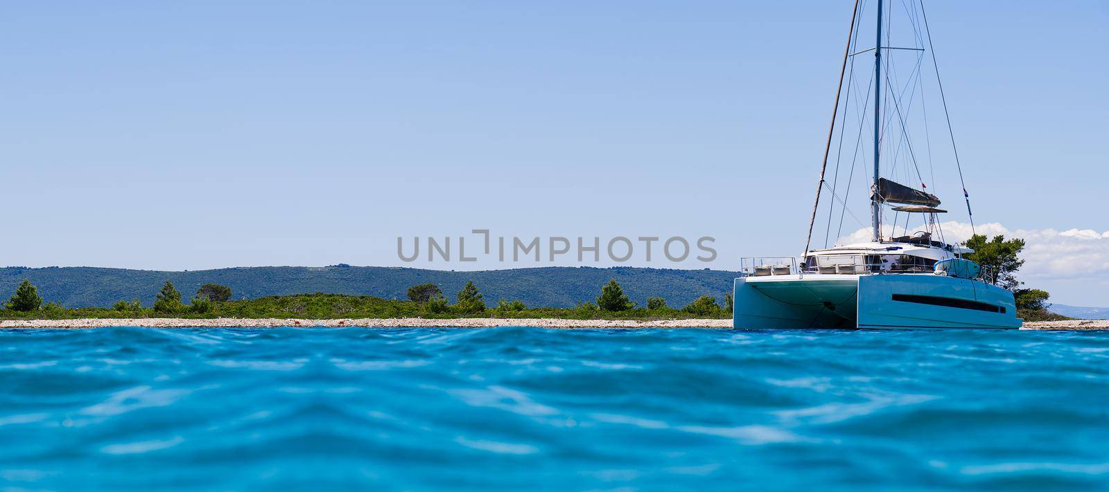 catamaran sailing in ocean. paradice at sea. Blue sky and turquoise blue sea water. by PhotoTime