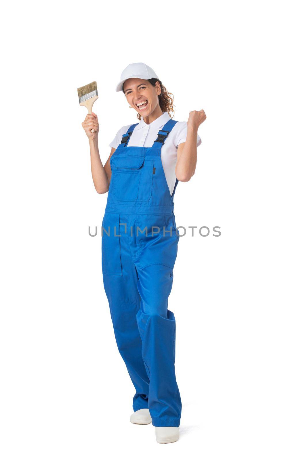 Female house painter with paint brush holding fists isolated on white background full length studio portrait