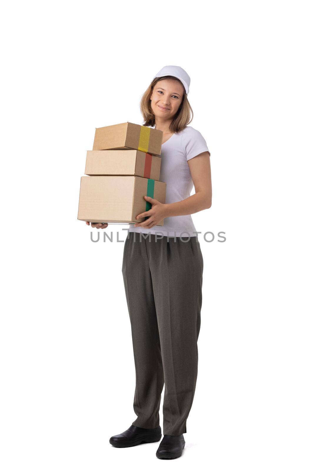 Full length portrait of delivery woman in white cap, t-shirt giving order boxes isolated on white background. Female courier step, cardboard box. Receiving package.