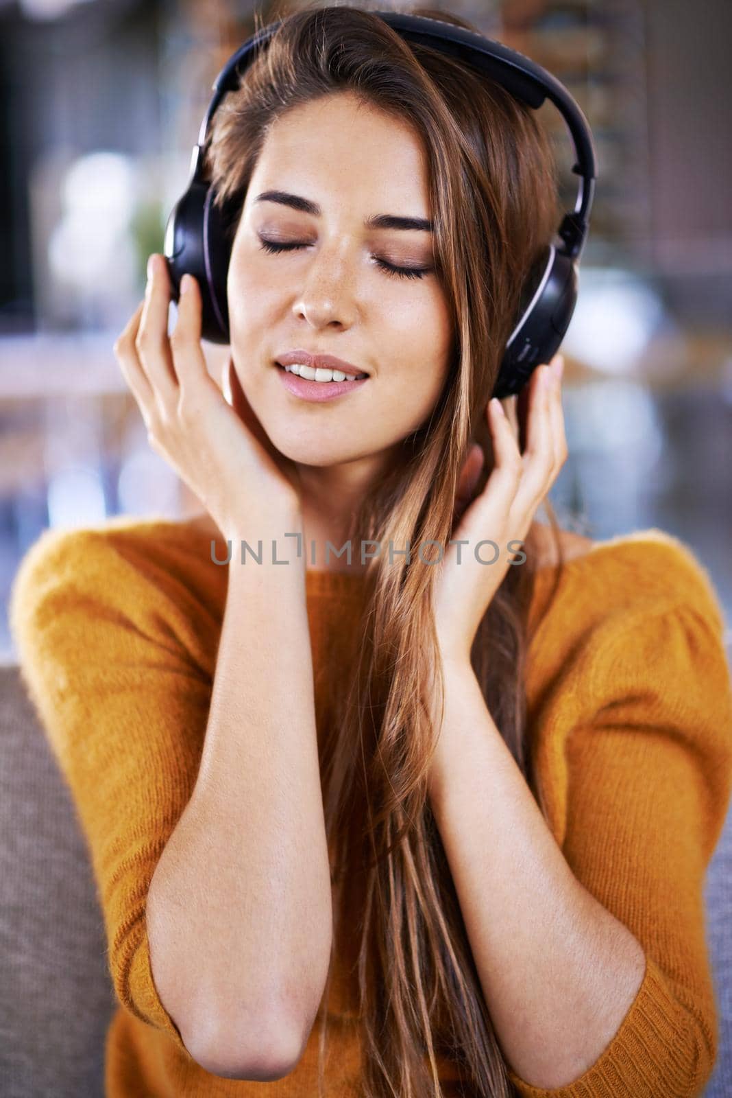 Its one of those relaxed playlists. Beautiful young woman listening to music at home