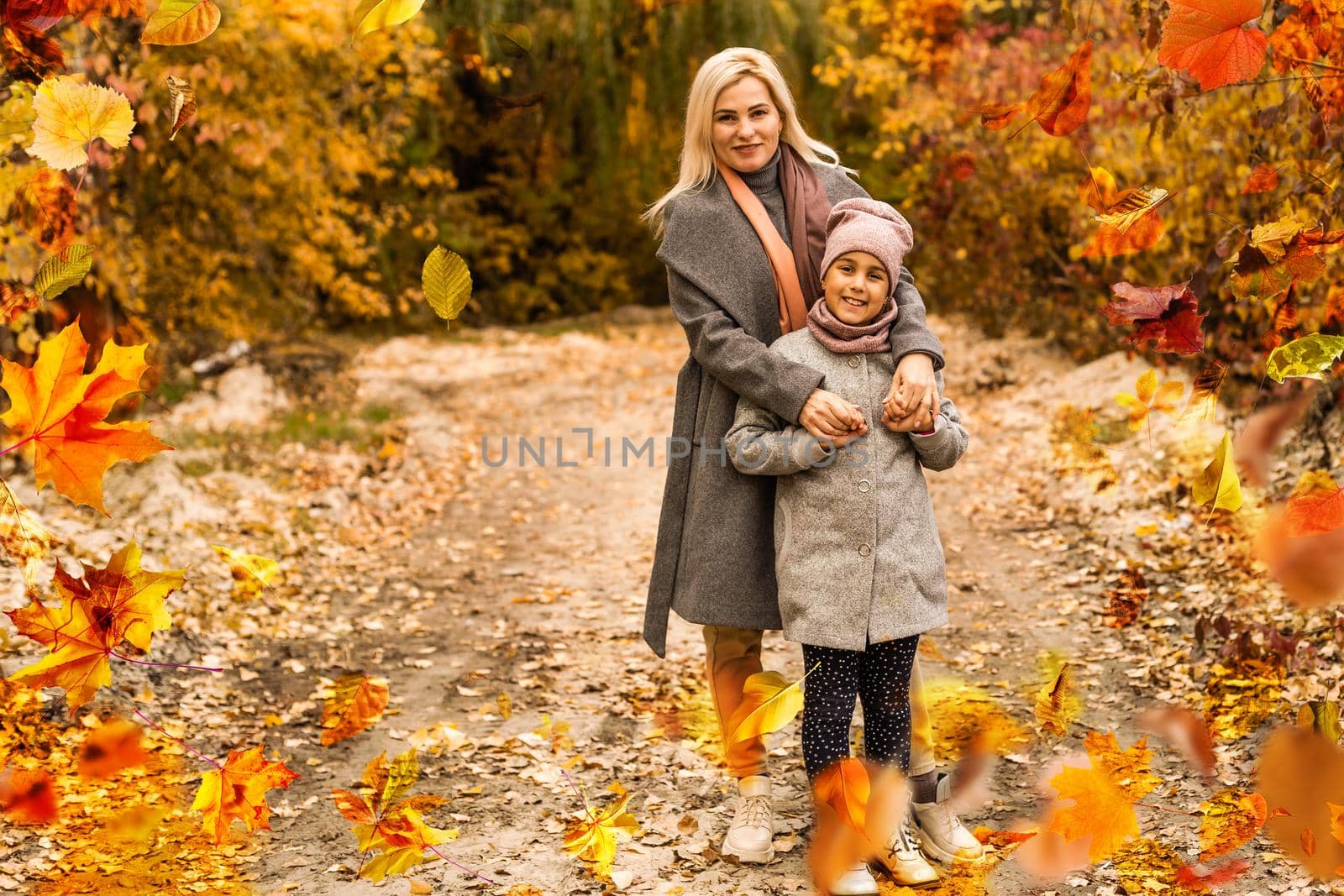 Happy family on autumn walk Mother and daughter walking in the Park and enjoying the beautiful autumn nature. High quality photo