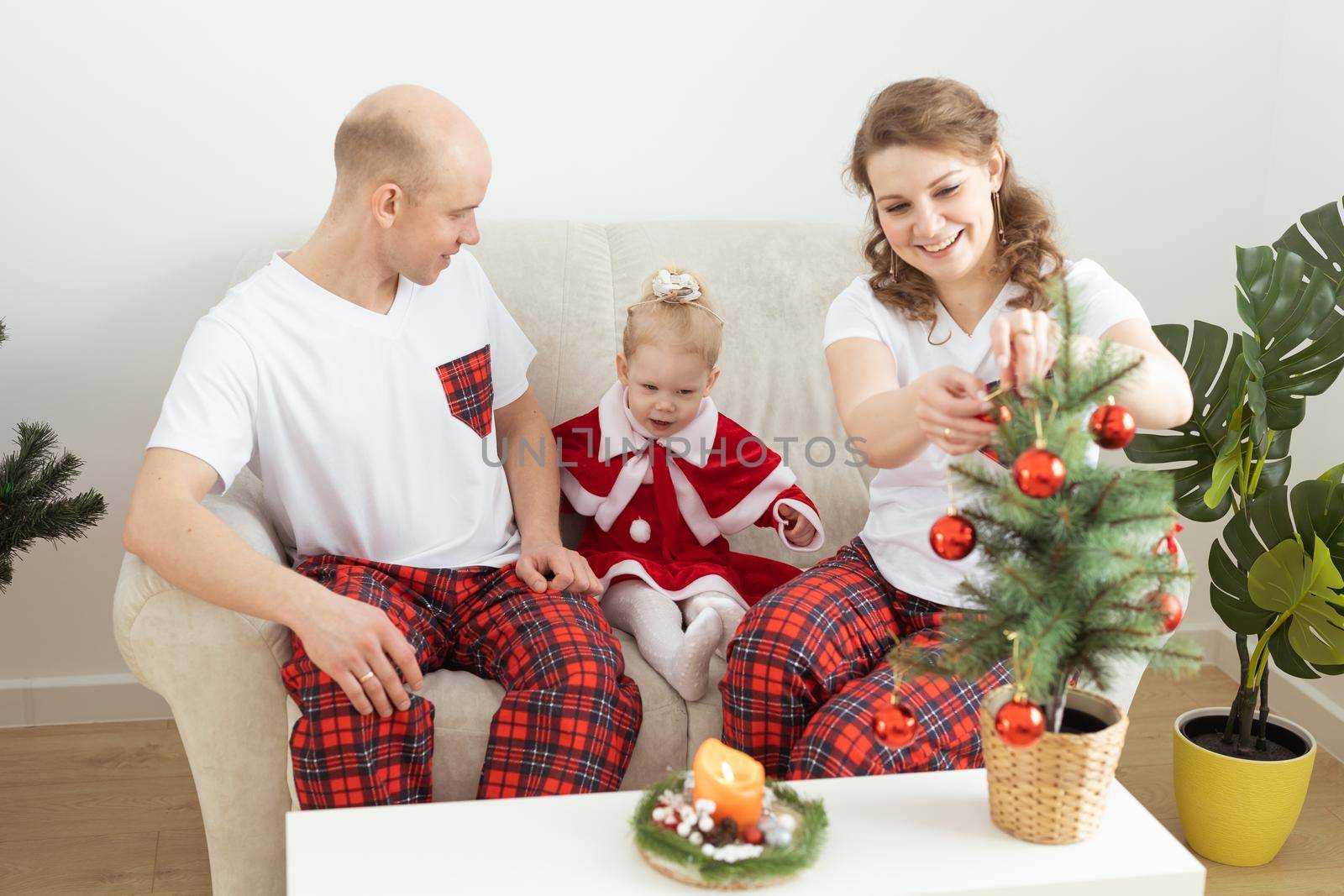 Child with cochlear implant hearing aid having fun with parents in christmas living room - diversity , deafness treatment and medical innovative technologies by Satura86