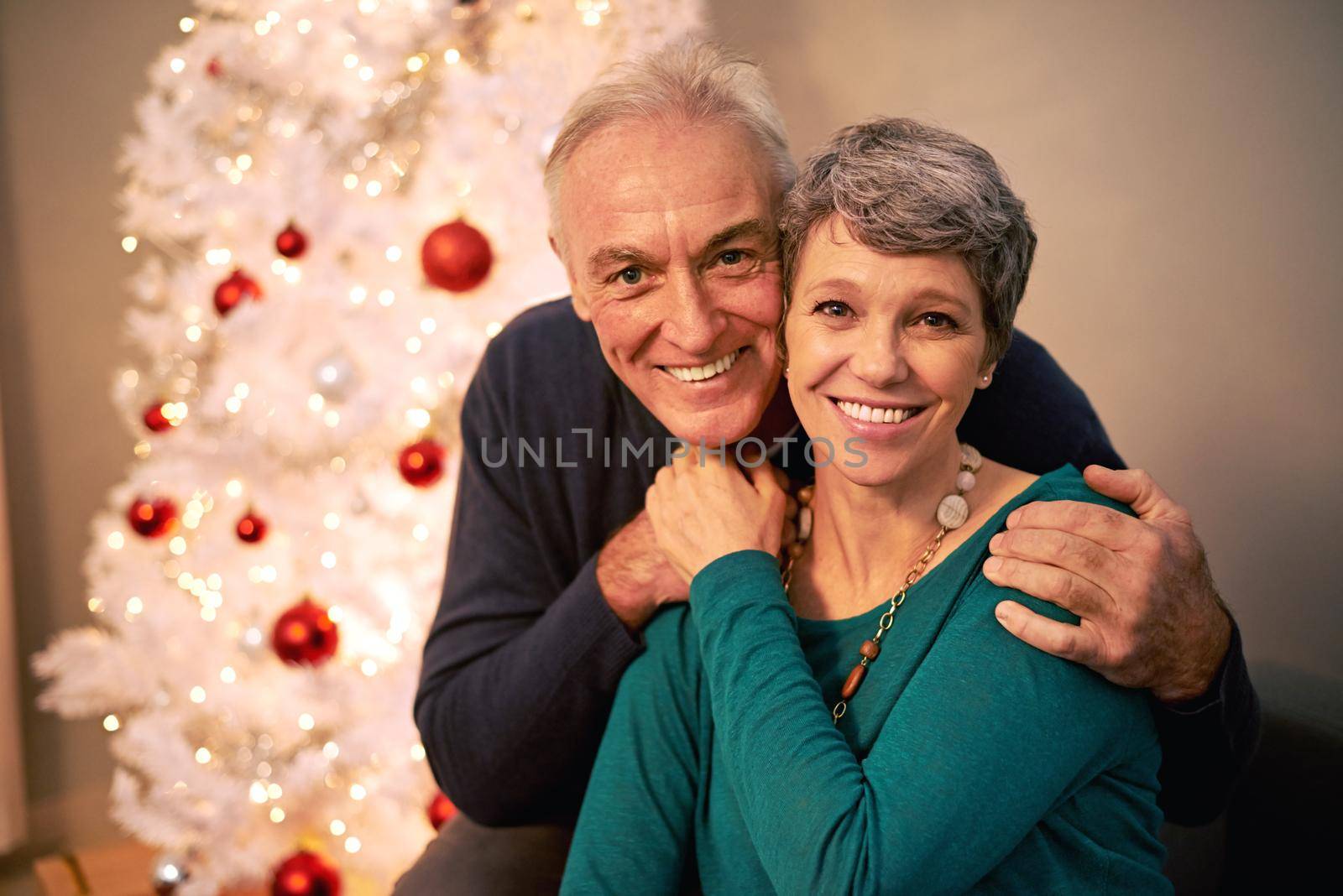 Its Christmas in the heart that puts Christmas in the air. Cropped portrait of a happy mature couple beside a Christmas tree. by YuriArcurs
