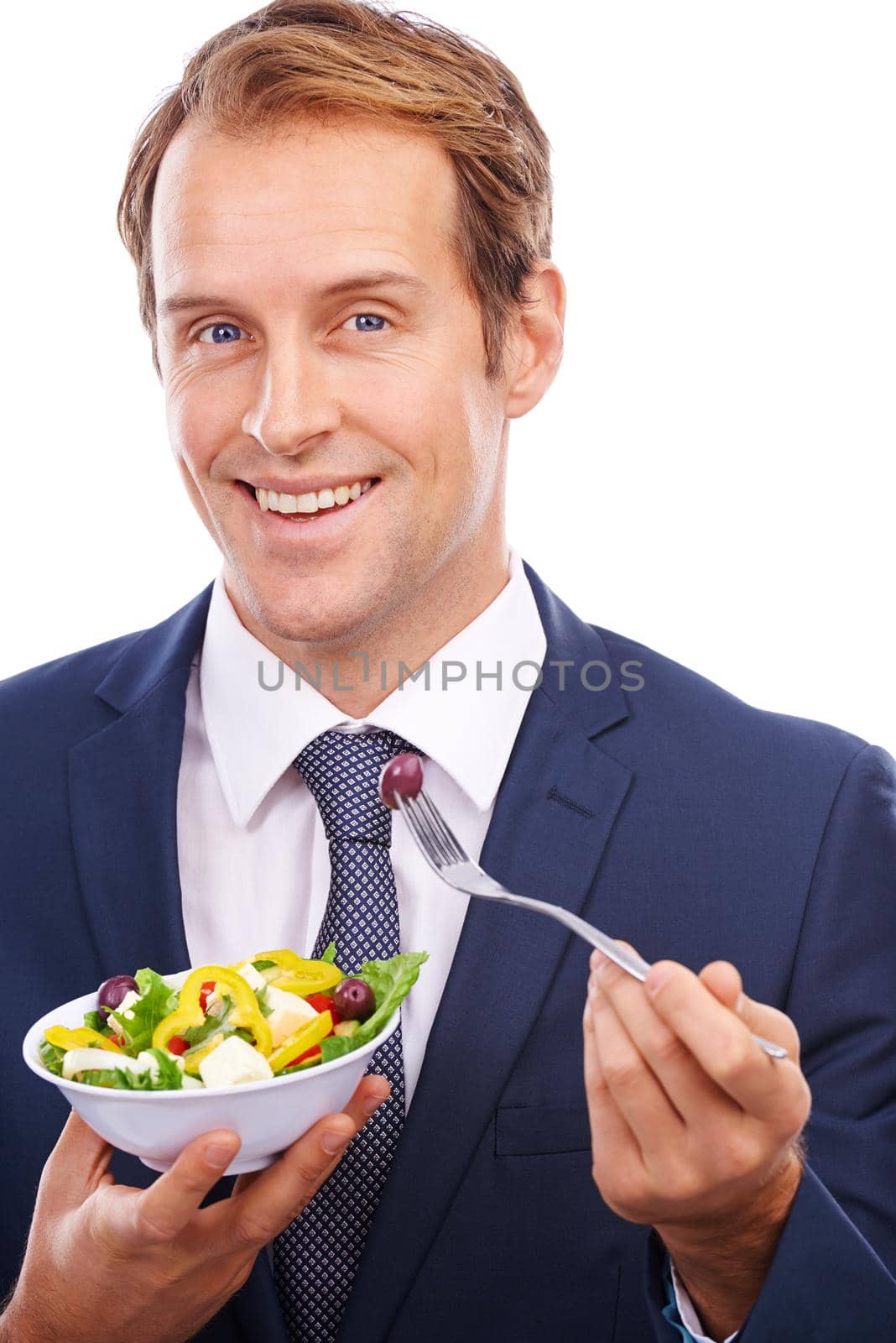 Getting it all for lunch. Portrait of a handsome young man eating salad isolated on white
