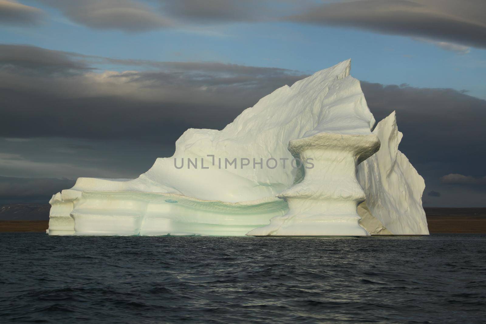 Stranded tabular iceberg and ice near evening in arctic landscape, near Pond Inlet, Nunavut, Canada