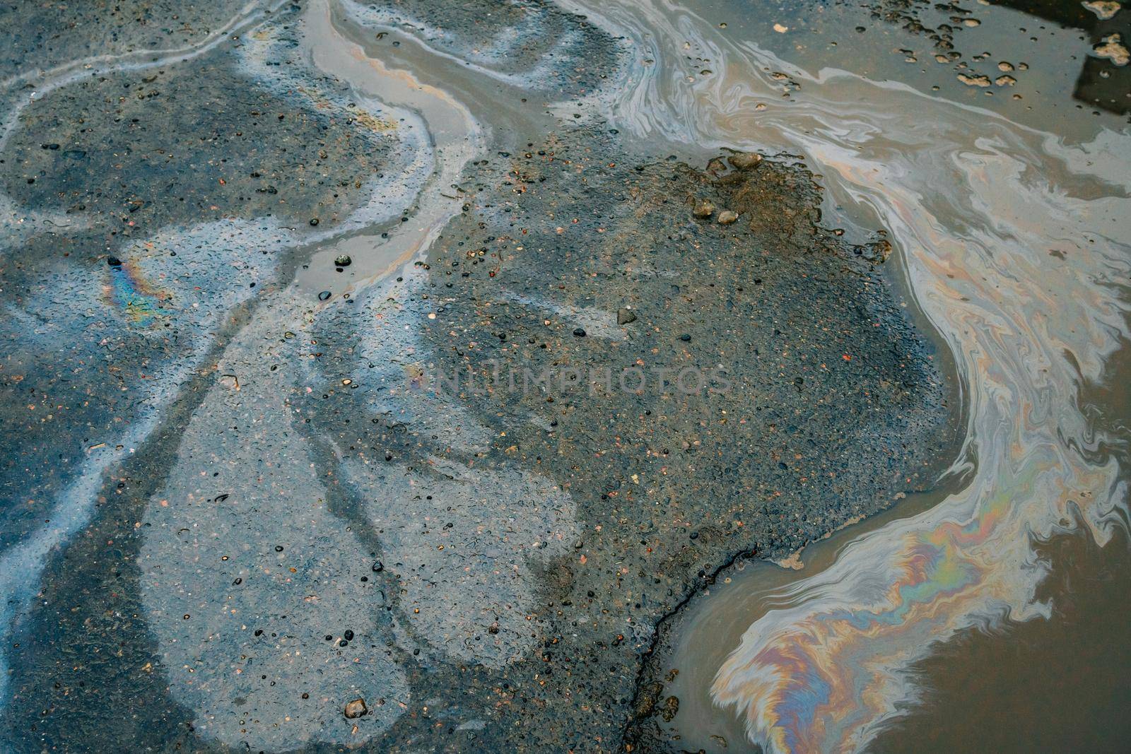 Beautiful abstract colorful background, stains of motor oil in a puddle with reflection of a building in blur. Selective focus