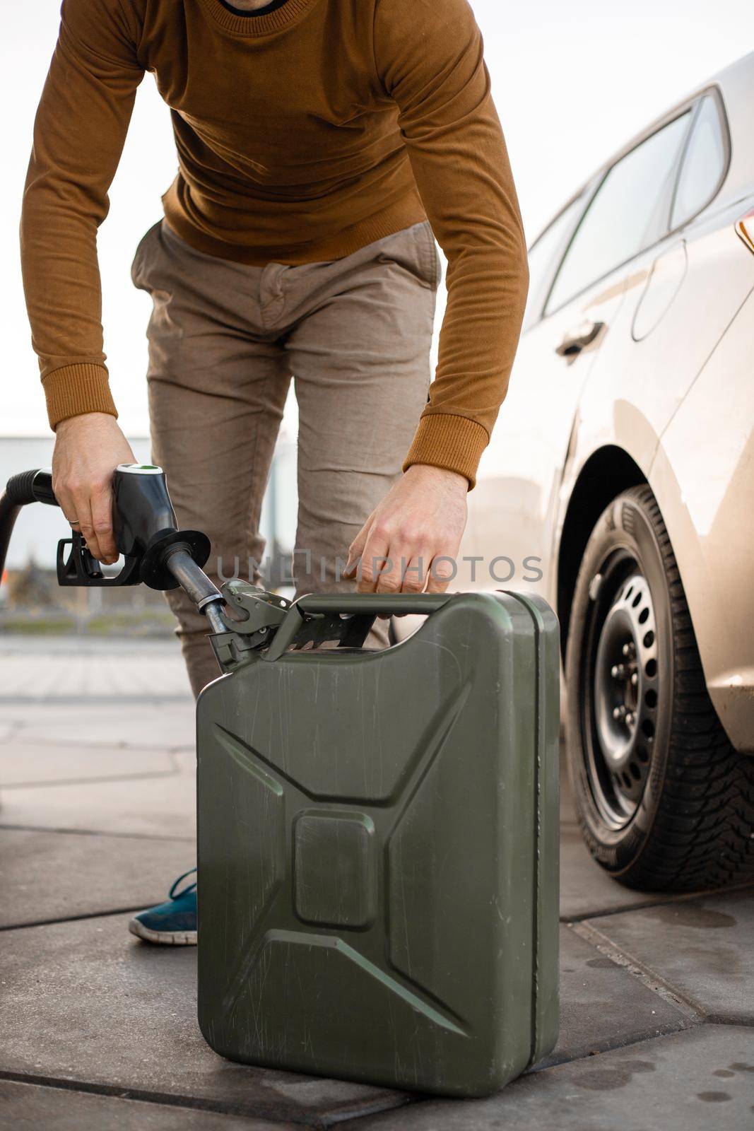 Man refilling canister with fuel on the petrol station. Close up view. Gasoline, diesel is getting more expensive