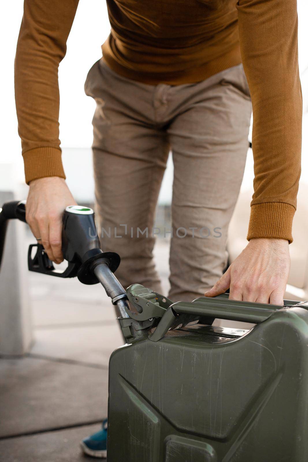 Man refilling canister with fuel on the petrol station. Close up view. Gasoline, diesel is getting more expensive
