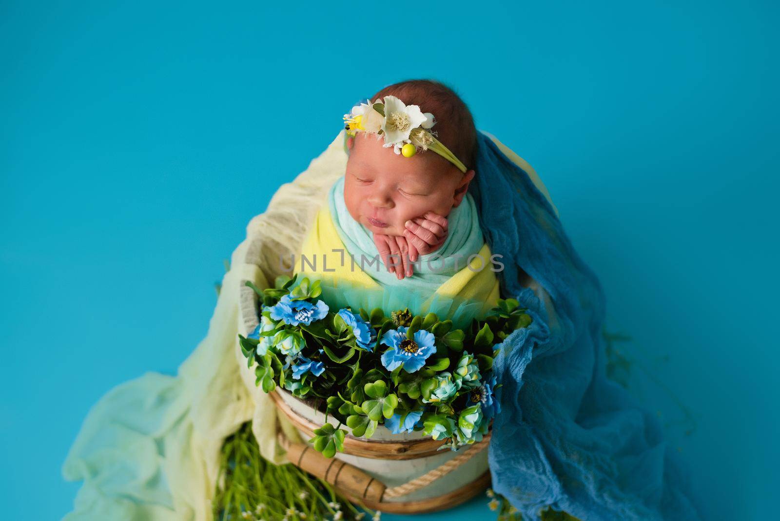 Ukrainian newborn in the studio patriotic blue yellow colors during the war in Ukraine 2022. A little baby, girl sleeps on isolated background