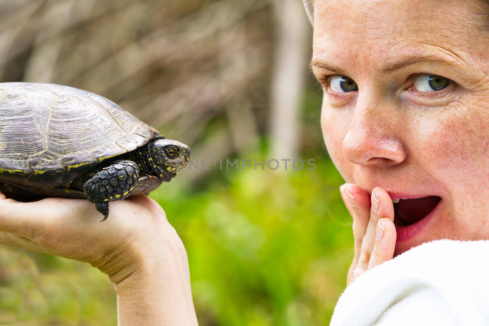Women hold European turtle, close up portrait. Happy women at the turtle sanctuary hatchery.
