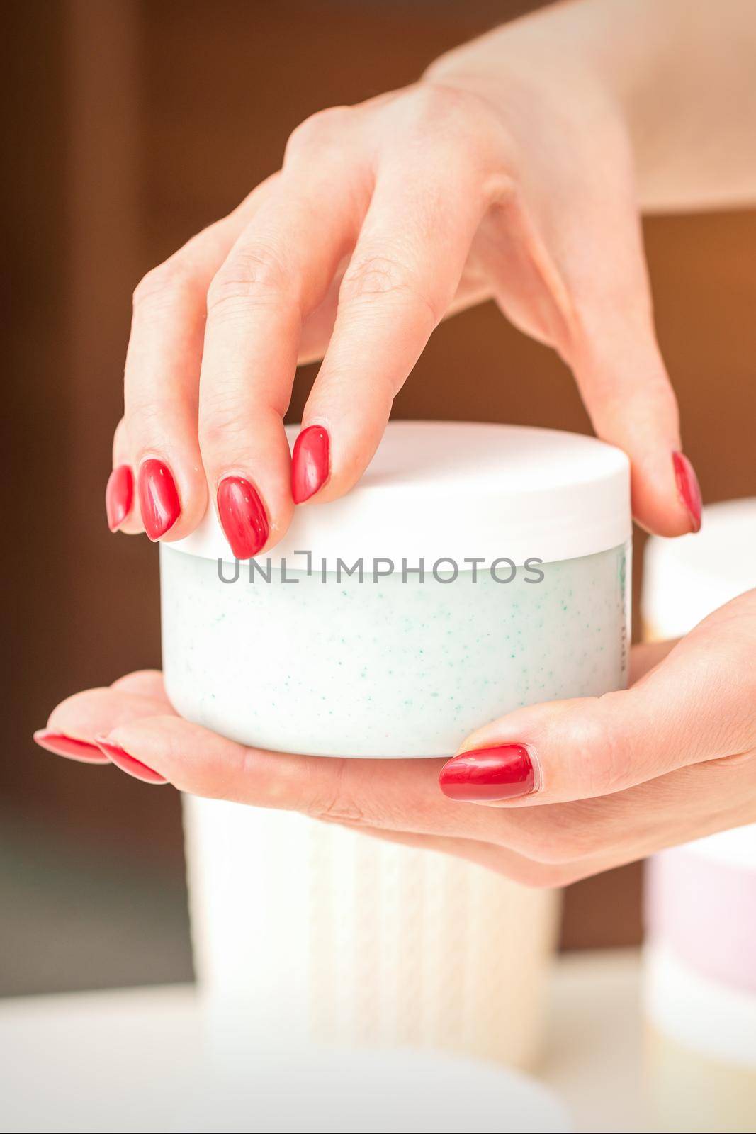 The woman opens the lid holding a jar of moisturizing cream, mockup, copy space, closeup