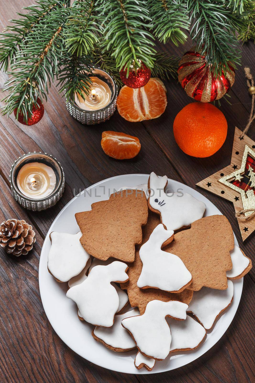 Delicious homemade Christmas cookies in the form of a rabbit and a Christmas tree on a wooden table decorated with New Year's decor.