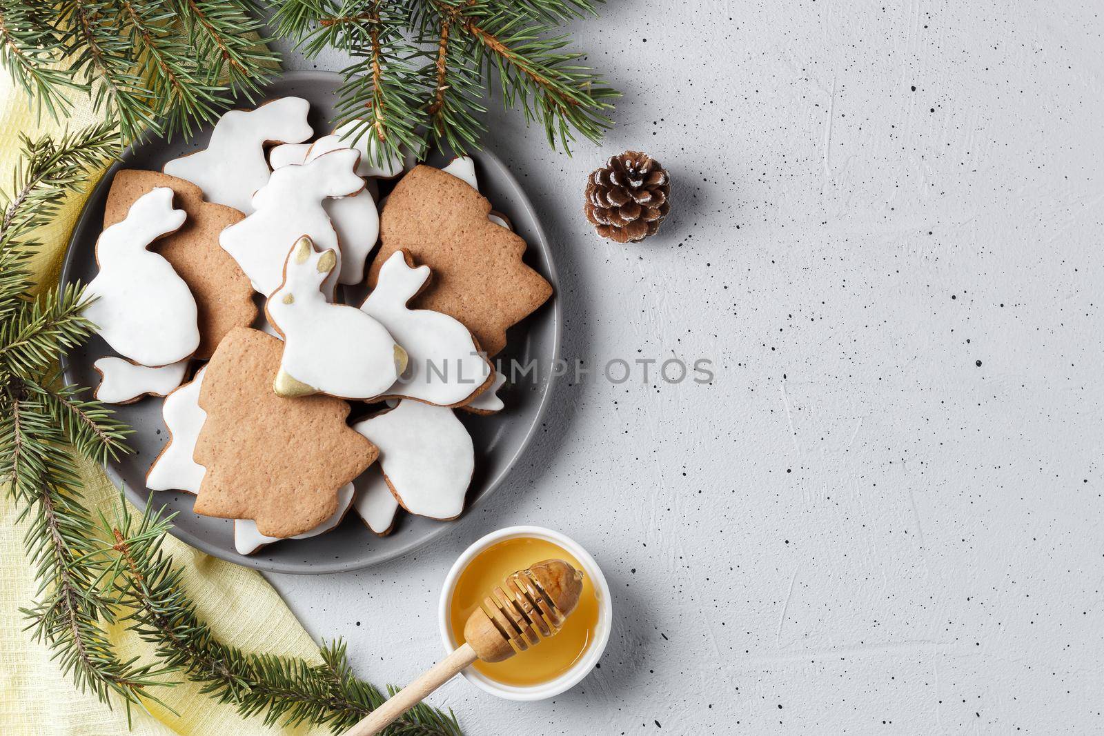 Delicious homemade Christmas cookies in the shape of a rabbit and a Christmas tree on a gray background decorated with New Year's decor. copy space