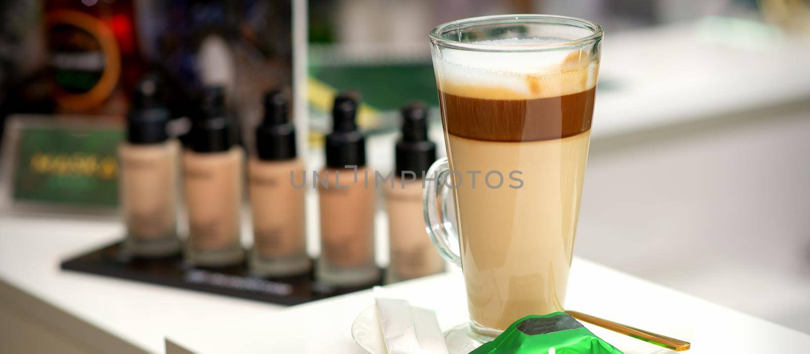 A cup of latte with candy on a saucer on the table in the manicure room. Manicure master place