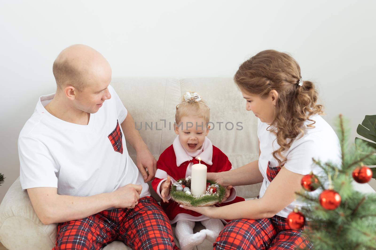 Baby child with hearing aid and cochlear implant having fun with parents in christmas room. Deaf and health