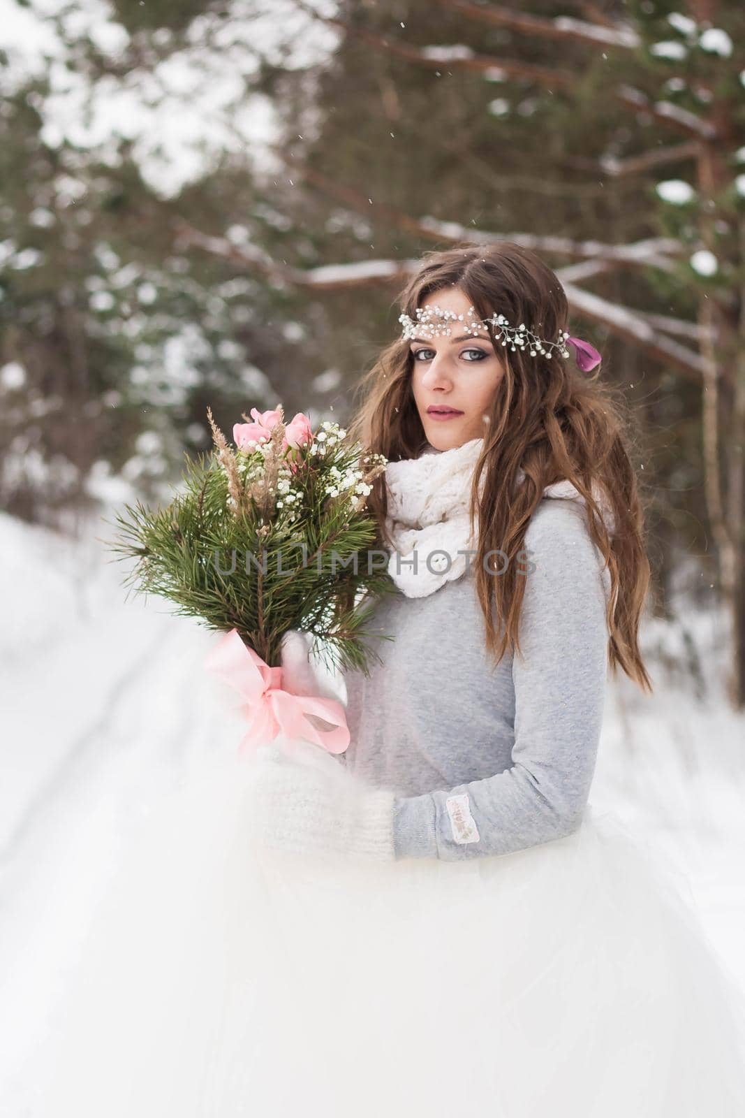 Beautiful bride in a white dress with a bouquet in a snow-covered winter forest. Portrait of the bride in nature by Annu1tochka