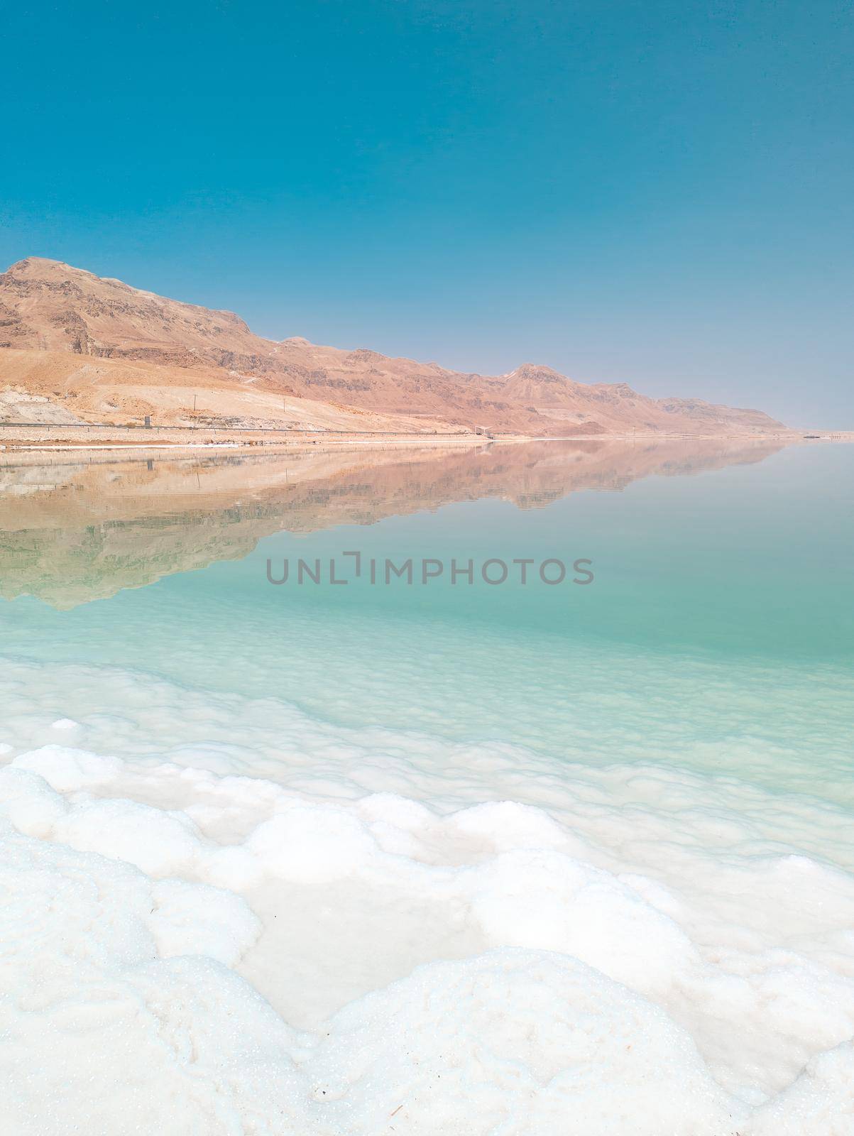 Landscape view on Dead Sea salt crystals formations, clear cyan green water and mountains at Ein Bokek beach, Israel by Len44ik