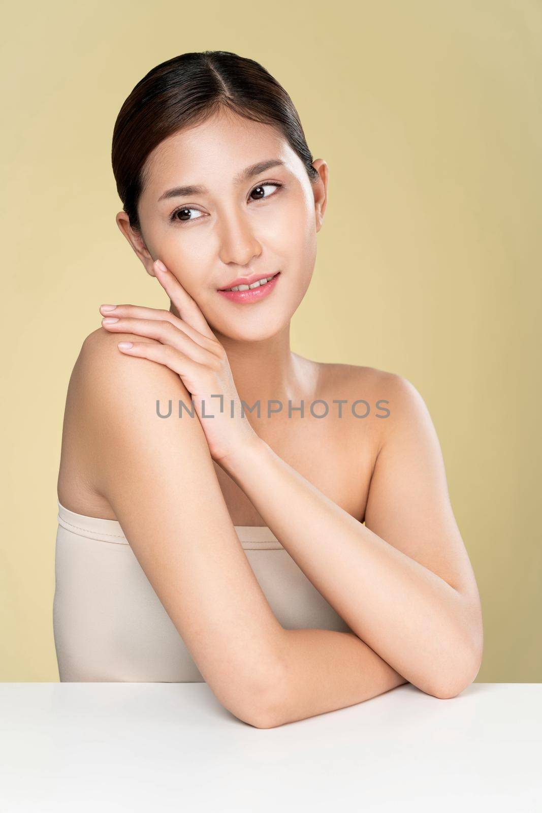 Portrait of ardent young woman with healthy clear skin and soft makeup looking at camera and posing beauty gesture. Cosmetology skincare and beauty concept.