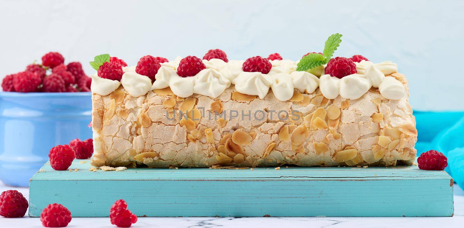 Baked meringue roll with cream and fresh red raspberry, white background	 by ndanko