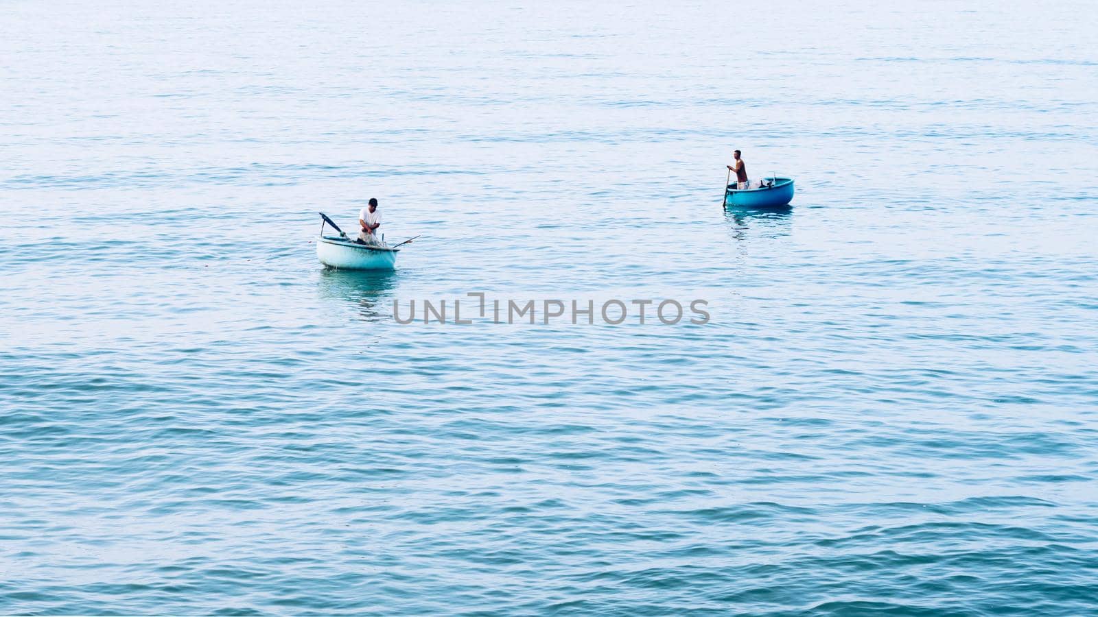 Simple background Calm dark blue sea fishing boats alone white pale Spindrift clouds Open way no limitations.