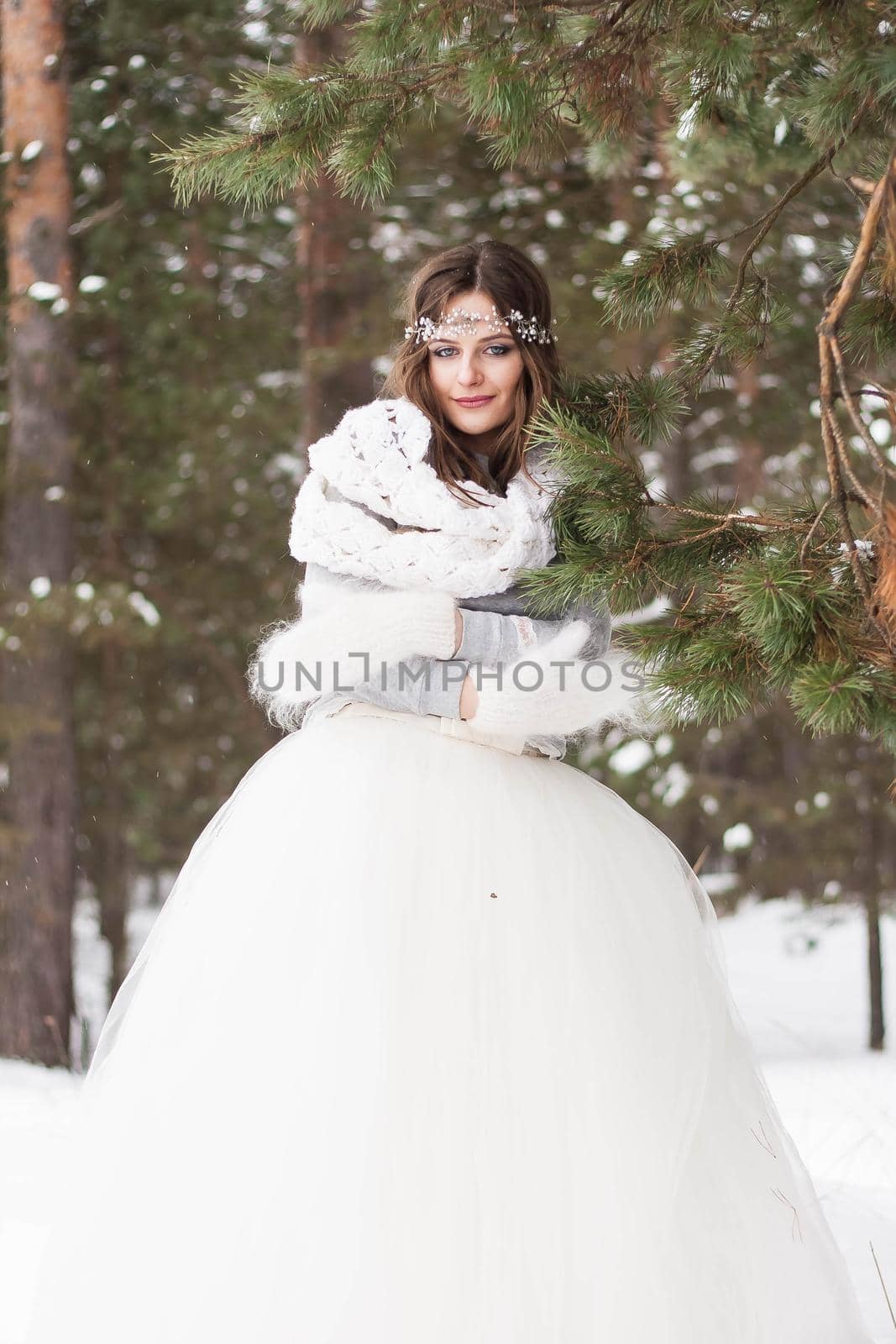 Beautiful bride in a white dress with a bouquet in a snow-covered winter forest. Portrait of the bride in nature by Annu1tochka