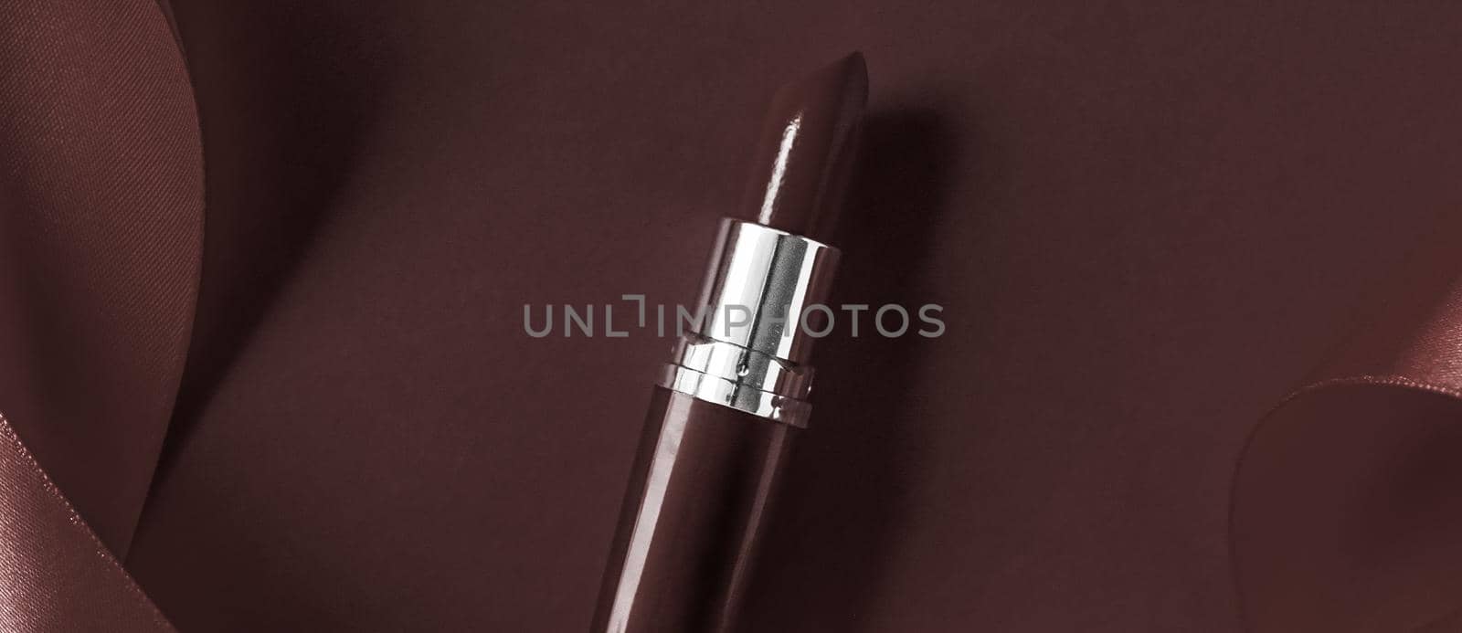 Cosmetic branding, glamour lip gloss and shopping sale concept - Luxury lipstick and silk ribbon on chocolate holiday background, make-up and cosmetics flatlay for beauty brand product design