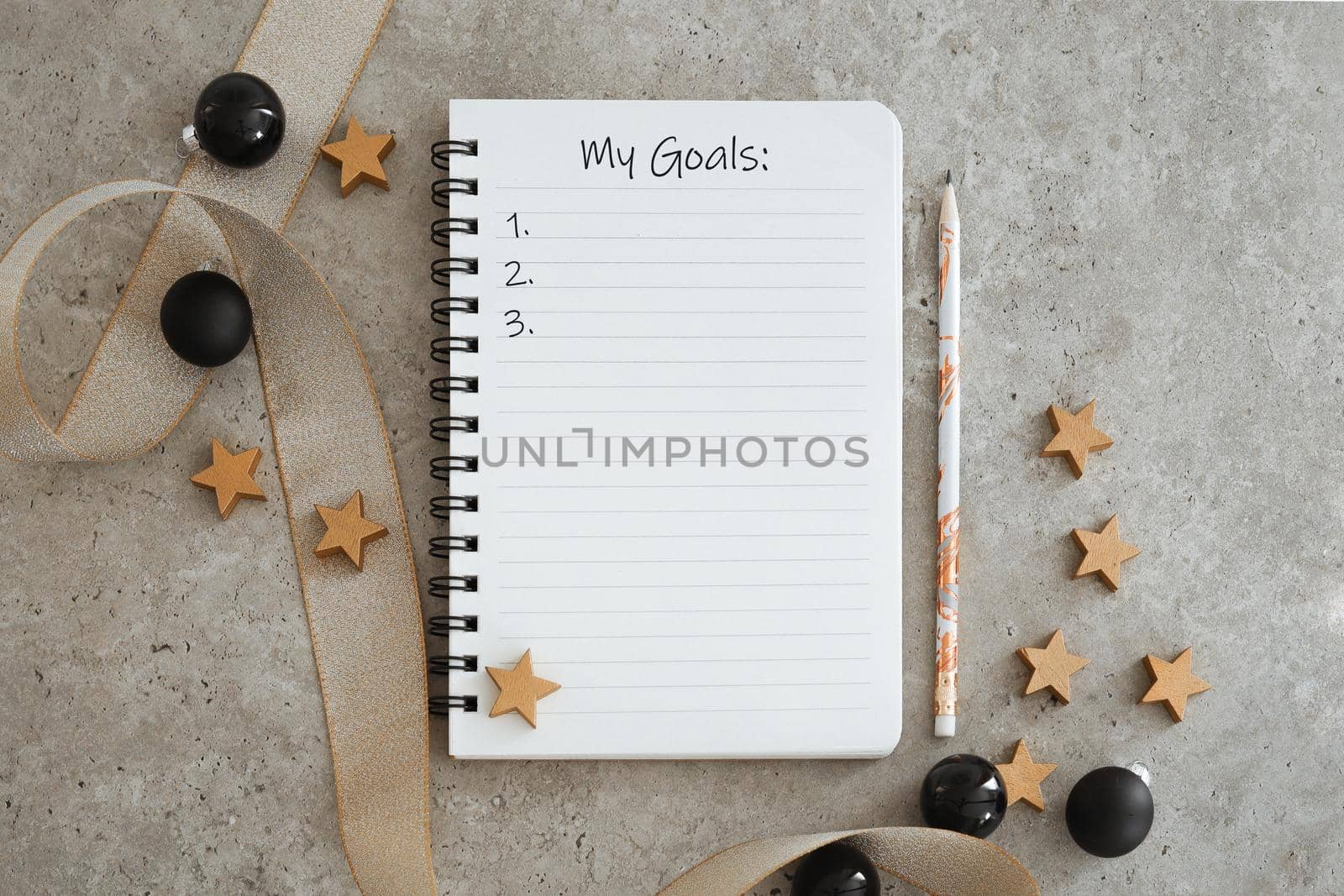 Top view of notebook with Christmas decorations. Goals list for new year. Free space, copy space, mockup or template for your text