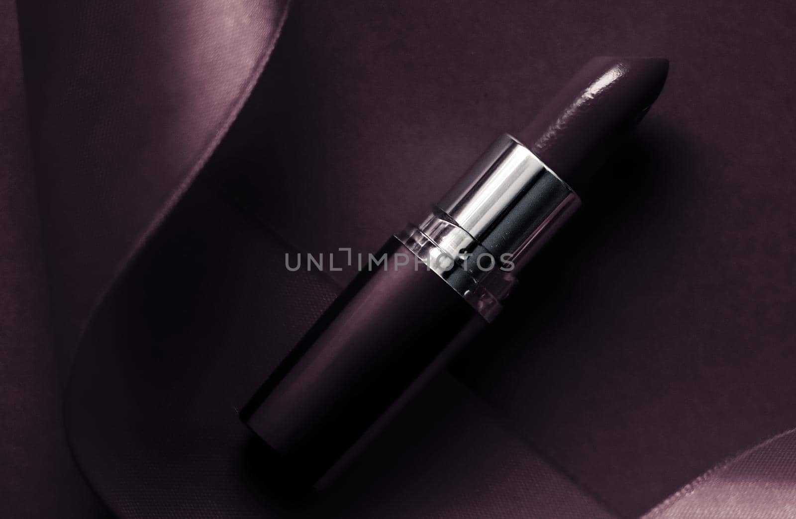 Luxury lipstick and silk ribbon on dark purple holiday background, make-up and cosmetics flatlay for beauty brand product design by Anneleven