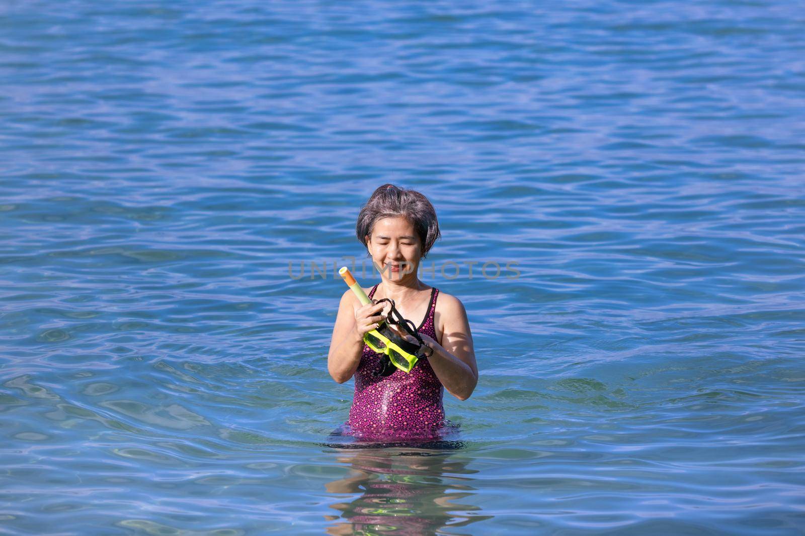 Senior asian woman with a mask for snorkeling in the sea. by toa55