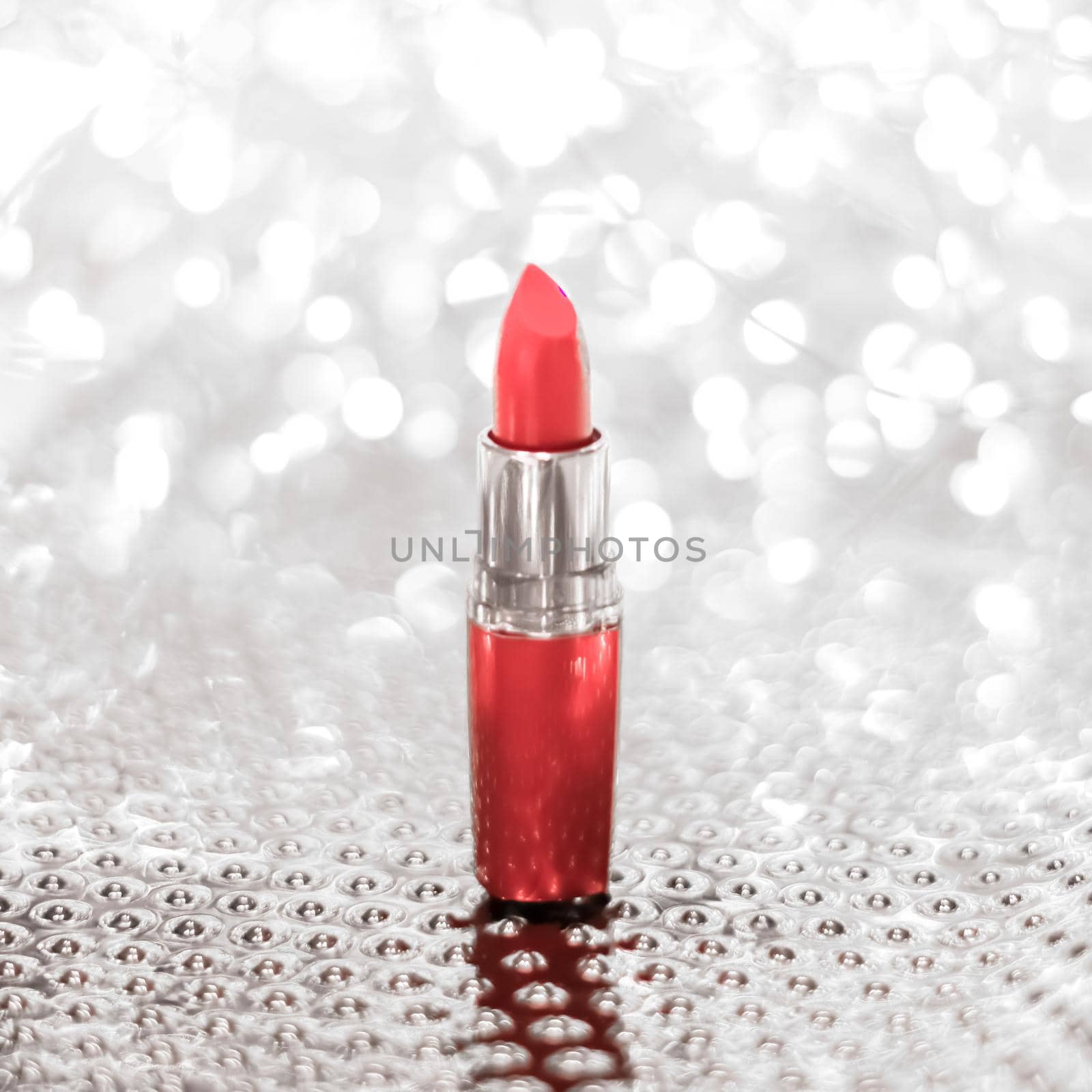Coral lipstick on silver Christmas, New Years and Valentines Day holiday glitter background, make-up and cosmetics product for luxury beauty brand by Anneleven