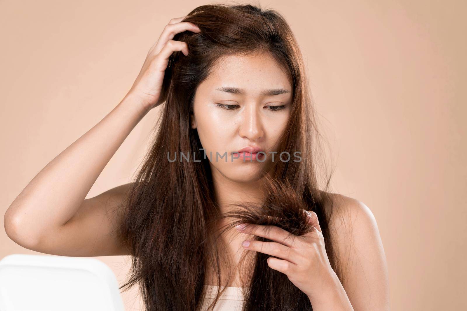 Ardent young girl feels insecure about her damaged hair. Beauty concept of brittle hair and how to treat it.