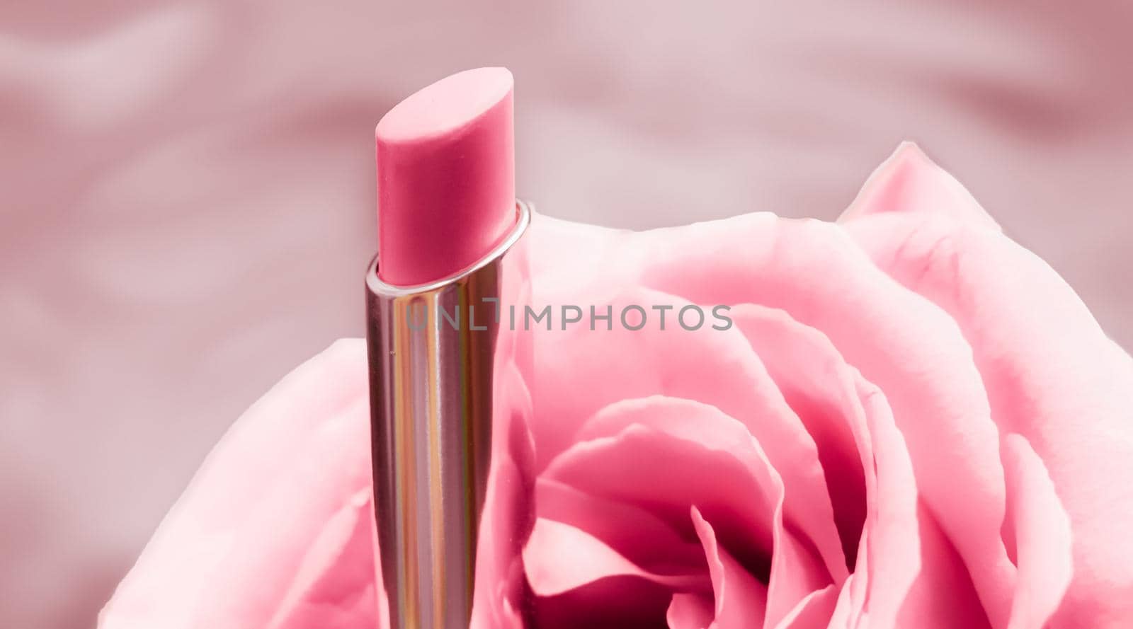 Pink lipstick and rose flower on liquid background, waterproof glamour make-up and lip gloss cosmetics product for luxury beauty brand holiday design by Anneleven