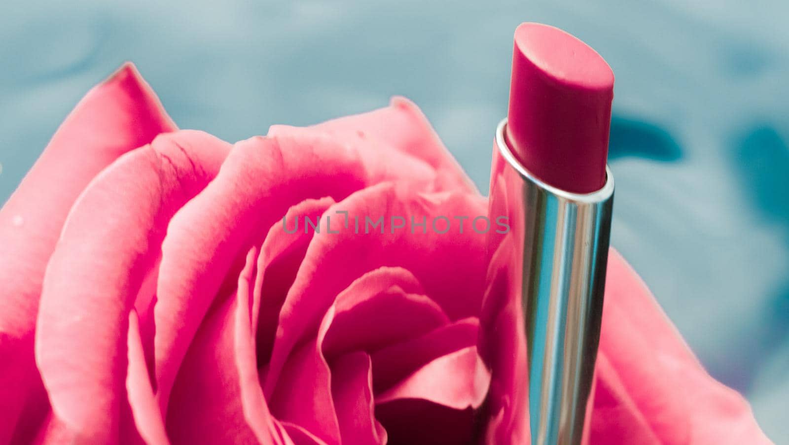 Pink lipstick and rose flower on liquid background, waterproof glamour make-up and lip gloss cosmetics product for luxury beauty brand holiday design by Anneleven