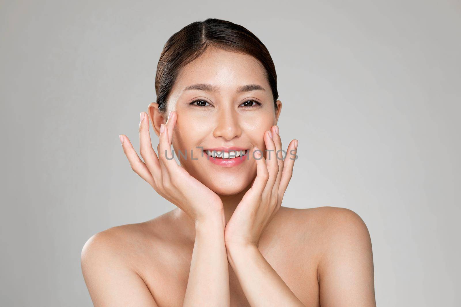 Portrait of ardent young woman with healthy clear skin and soft makeup looking at camera and posing beauty gesture. Cosmetology skincare and beauty concept.