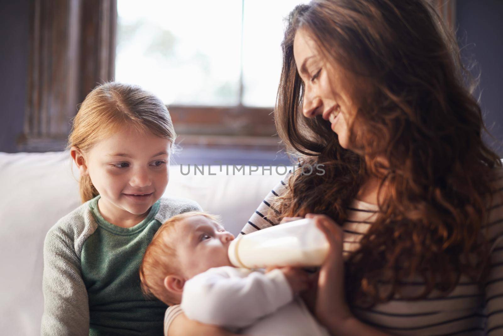 She loves her little sister. A shot of a family spending time together while mom nurses baby
