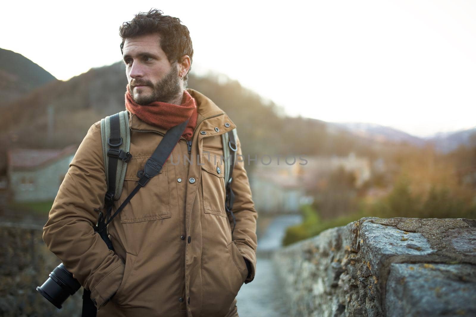 Handsome man standing outdoors in nature in winter. Male photographer going on trekking, hiking adventure. Copy space. Lifestyle.