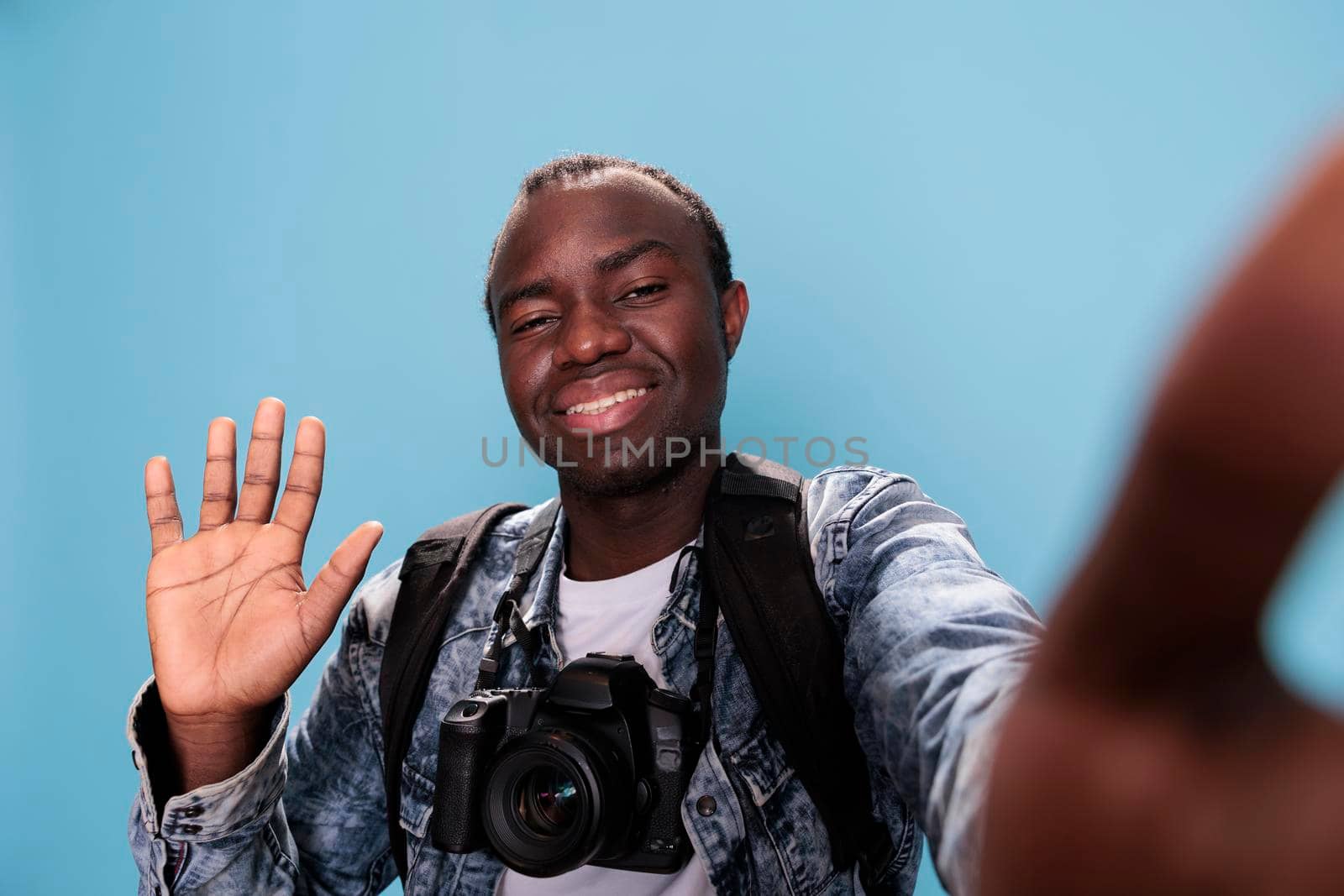Smiling young photography enthusiast having DSLR device and taking selfie by DCStudio