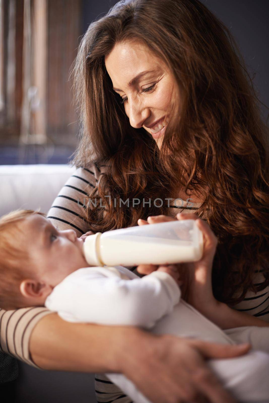 Milk to help her grow. an adoring mother giving her baby a bottle