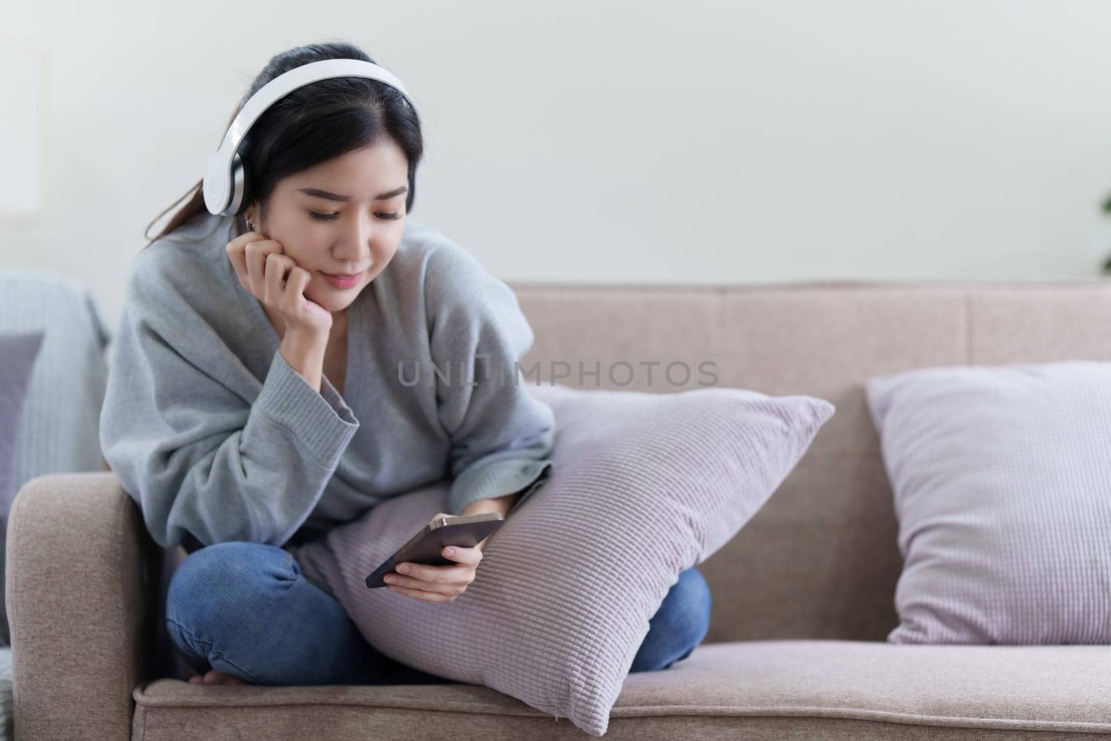 Asian woman checking social media by phone and listen music. lifestyle concept by itchaznong