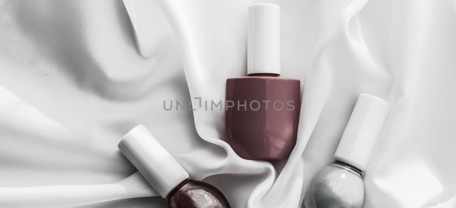 Cosmetic branding, salon and glamour concept - Nail polish bottles on silk background, french manicure products and nailpolish make-up cosmetics for luxury beauty brand and holiday flatlay art design