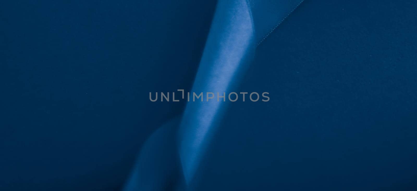 Branding, holidays and luxe brands concept - Abstract silk ribbon on royal blue background, exclusive luxury brand design for holiday sale product promotion and glamour art invitation card backdrop